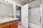 Well-lit bathroom with shower tub combo